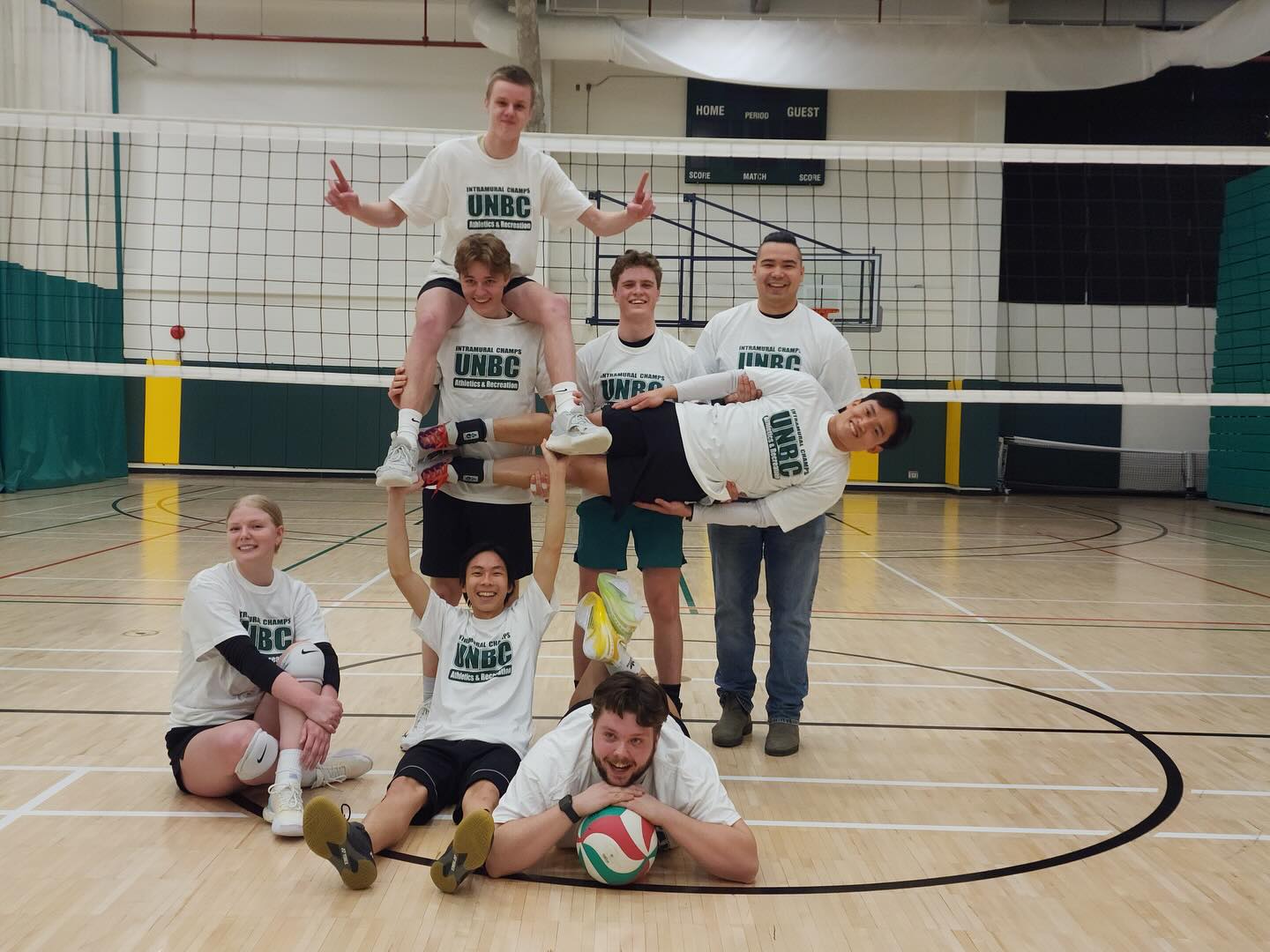 UNBC Intramurals volleyball players celebrating together after a campus league night.