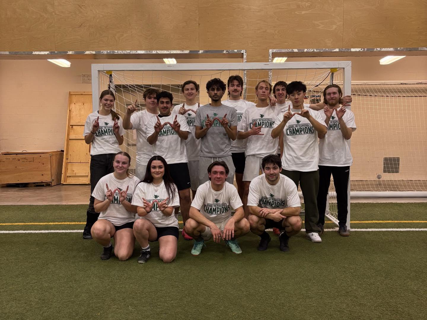 UNBC Intramurals champions posing together on the indoor soccer field.